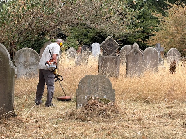 Strimming gets underway among the gravestones.